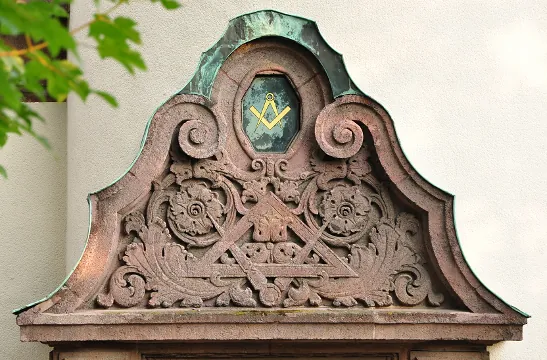 Giebelaufsatz über dem Portal mit Winkelmaß und Zirkel